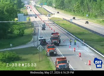 Road work with personnel and vehicles on the shoulder of I-39.