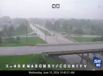 Roadway is flooded due to heavy rain, causing hazardous driving conditions.