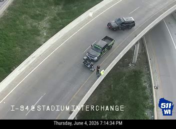 Two vehicles and a motorcycle stopped on the highway with personnel present.