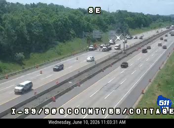 Emergency responders and vehicles are present on the highway, with traffic cones visible.