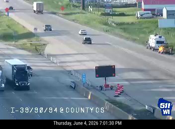 Emergency responders and equipment are present on the right shoulder of the highway.