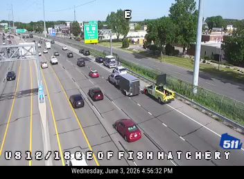 Yellow tow truck with flashing lights on the right shoulder of the highway.