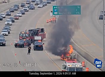 Truck on fire in the right lane with emergency responders present