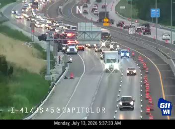 Multiple emergency vehicles with red and blue lights on the roadway