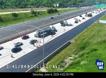 Multiple vehicles stopped on highway, some appear damaged, indicating a crash.
