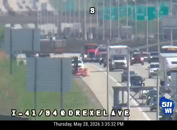 Emergency vehicle and personnel on the side of the road with traffic stopped.